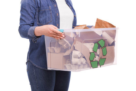 Recycling. Woman holding plastic box with different waste paper on white background, closeupの写真素材