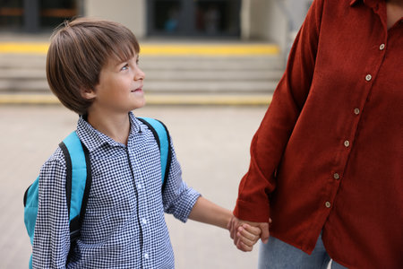 Mother taking her son to school outdoors, closeupの写真素材