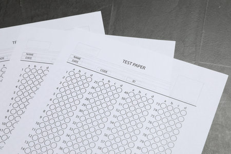 Answer sheets on gray textured table, closeup. Student passing examの写真素材