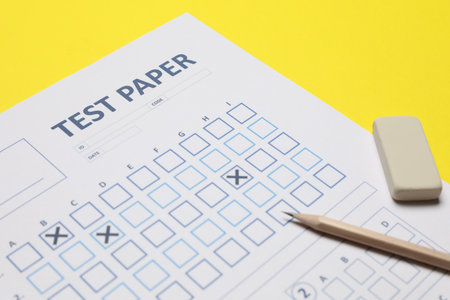 Answer sheet, pencil and eraser on yellow background, closeup. Student passing examの写真素材