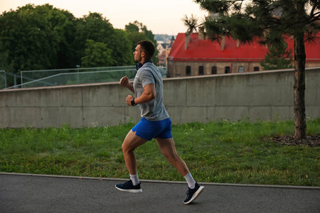 Athletic young man in sportswear running outdoors
