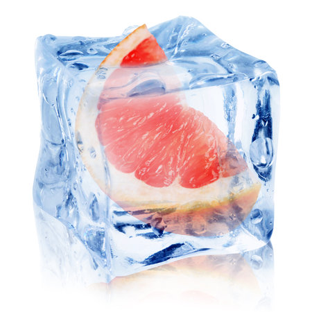 Piece of fresh grapefruit inside ice cube on white backgroundの写真素材