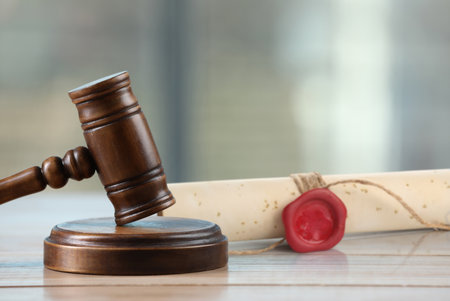 Wooden gavel and old rolled paper scroll on tableの写真素材