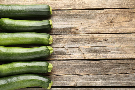 Fresh ripe zucchinis on wooden table, flat lay. Space for textの写真素材