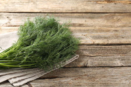 Bunch of fresh dill on wooden table, closeup. Space for textの写真素材