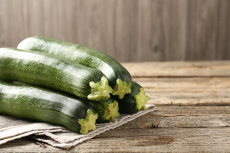 Fresh ripe zucchinis on wooden table, closeup. Space for textの写真素材