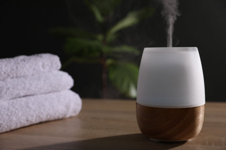 Modern aroma lamp on wooden table indoors