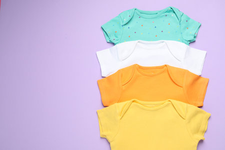 Stylish baby clothes on violet background, flat lay. Space for textの写真素材