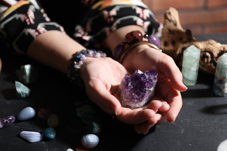Woman with healing stones at black table, closeupの写真素材