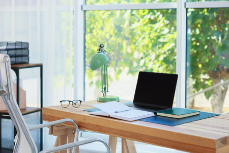 Home workplace. Laptop and stationery on wooden tableの写真素材