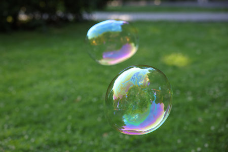 Beautiful transparent soap bubbles floating in parkの写真素材