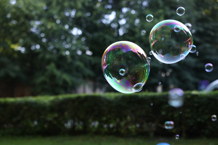 Beautiful transparent soap bubbles floating in parkの写真素材