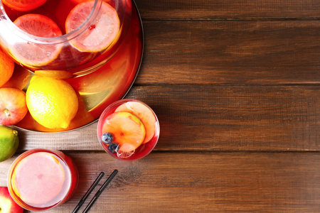 Tasty punch and fruits on wooden table, flat lay with space for text. Refreshing drinkの写真素材