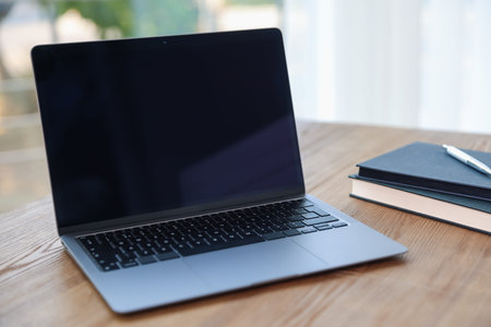 Home workspace. Laptop and stationery on wooden desk indoors, closeup