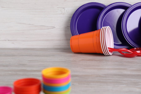 Set of disposable plastic tableware on light grey wooden table, closeupの写真素材
