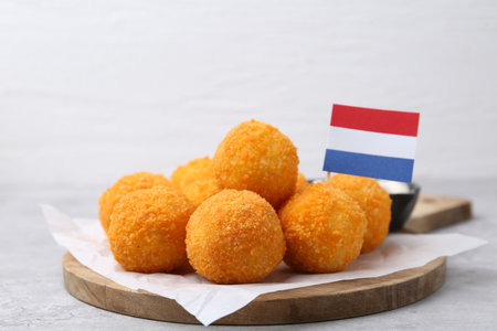 Delicious fried croquette balls and flag of Netherlands on gray table, closeupの写真素材