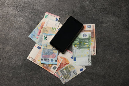 Smartphone and euro banknotes on grey table, flat layの写真素材