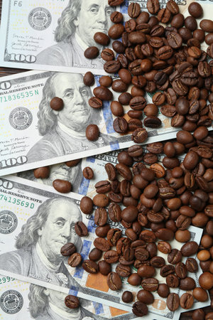 Roasted coffee beans and dollar banknotes on table, top viewの写真素材