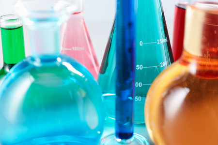 Different laboratory glassware with color liquids on light background, closeupの写真素材