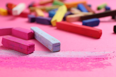 Many colorful chalk pastels on pink background, closeupの写真素材