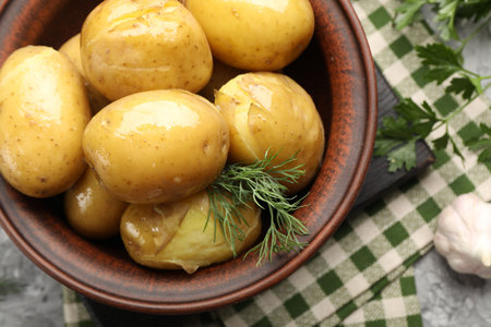 Tasty young boiled potatoes with dill, oil in bowl and products on grey table, flat layの写真素材