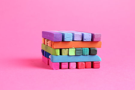 Many colorful chalk pastels on pink backgroundの写真素材