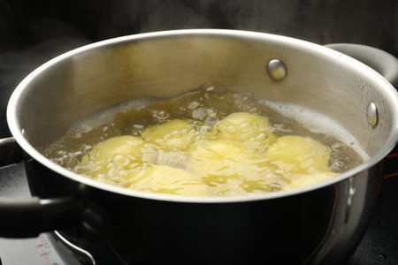 Young potatoes boiling in pot on stove, closeupの写真素材