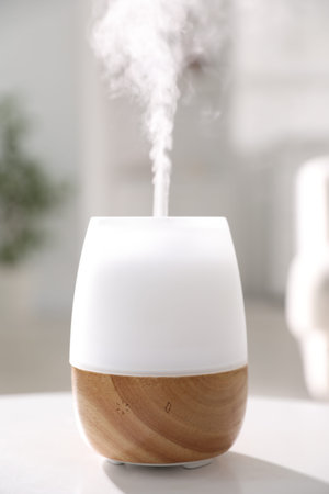 One stylish aroma lamp on white table indoors, closeup