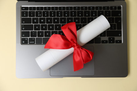 Laptop and diploma on beige background, top viewの写真素材