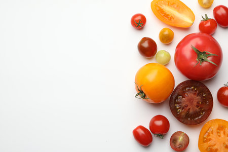 Different ripe tomatoes on white table, flat lay. Space for textの写真素材