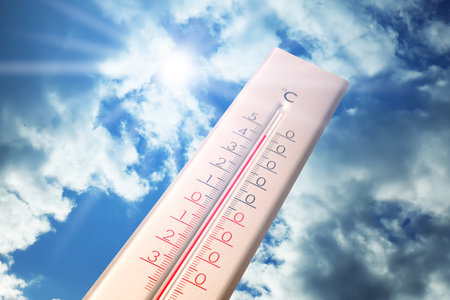 Extremely high temperature on thermometer against blue sky on sunny day. Summer weatherの写真素材