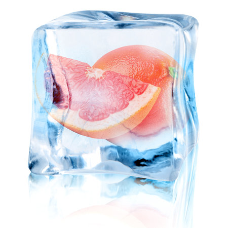 Fresh grapefruits inside ice cube on white backgroundの写真素材