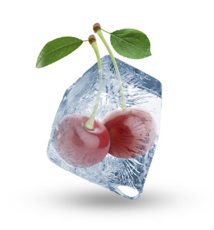Fresh cherries in clear ice cube isolated on whiteの写真素材