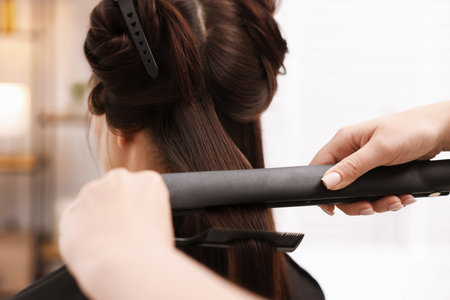 Hairdresser laminating woman's hair in salon, closeupの写真素材