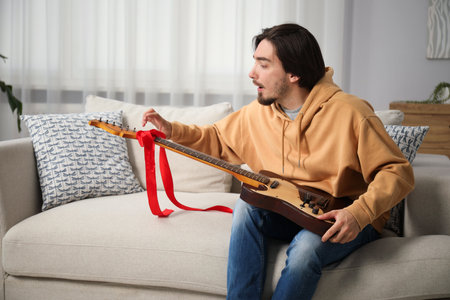 Dreams come true. Excited man with guitar at home, space for textの写真素材