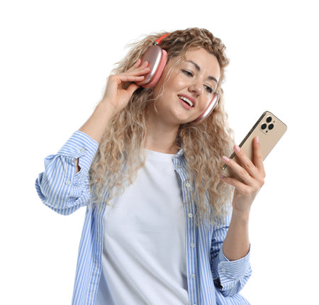 Happy woman with smartphone listening to music in headphones on white backgroundの写真素材
