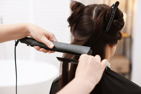 Hairdresser laminating woman's hair in salon, closeupの写真素材