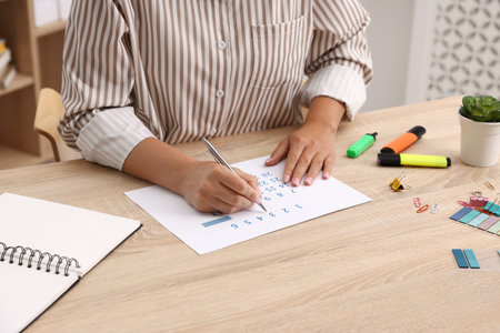 Business planning. Woman using calendar at wooden table in office, closeupの写真素材