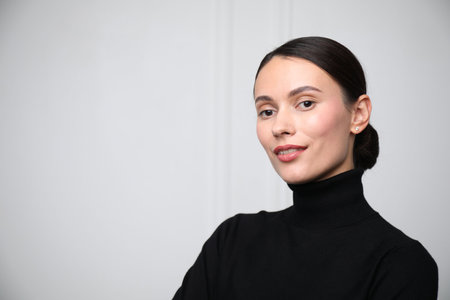 Portrait of beautiful woman near white wall. Space for textの写真素材