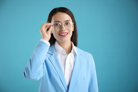 Portrait of confident businesswoman on light blue backgroundの写真素材