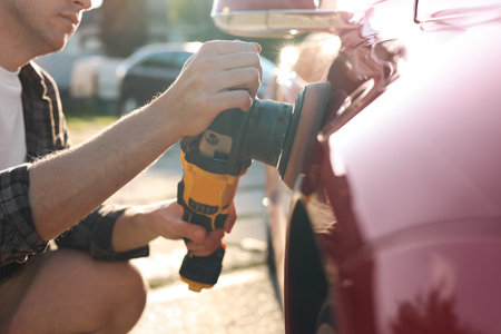 Man polishing car with orbital polisher outdoors, closeupの写真素材