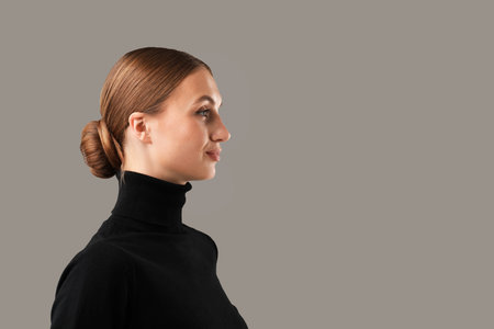 Portrait of confident woman on gray background. Space for text