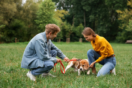 Couple spending time with adorable Beagle dog outdoors