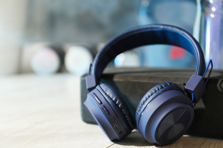 Wireless headphones, bottle of water on floor in room, closeup. Space for textの写真素材