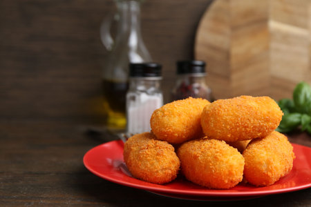 Delicious fried croquettes on wooden table, closeup