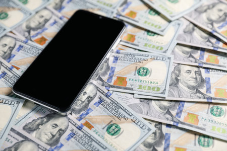 Smartphone on dollar banknotes as background, closeupの写真素材