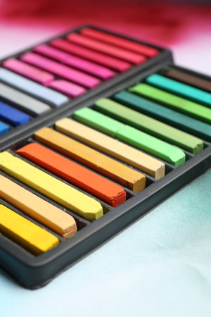 Colorful chalk pastels in trays on color background, closeupの写真素材
