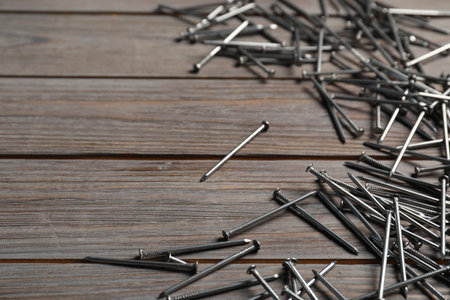 Many metal nails on wooden table, closeup. Space for textの写真素材