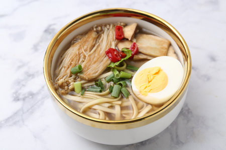 Tasty ramen with enoki and king oyster (eryngii) mushrooms on white marble table, closeupの写真素材