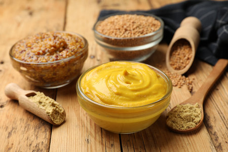 Different types of mustard on wooden table, closeupの写真素材